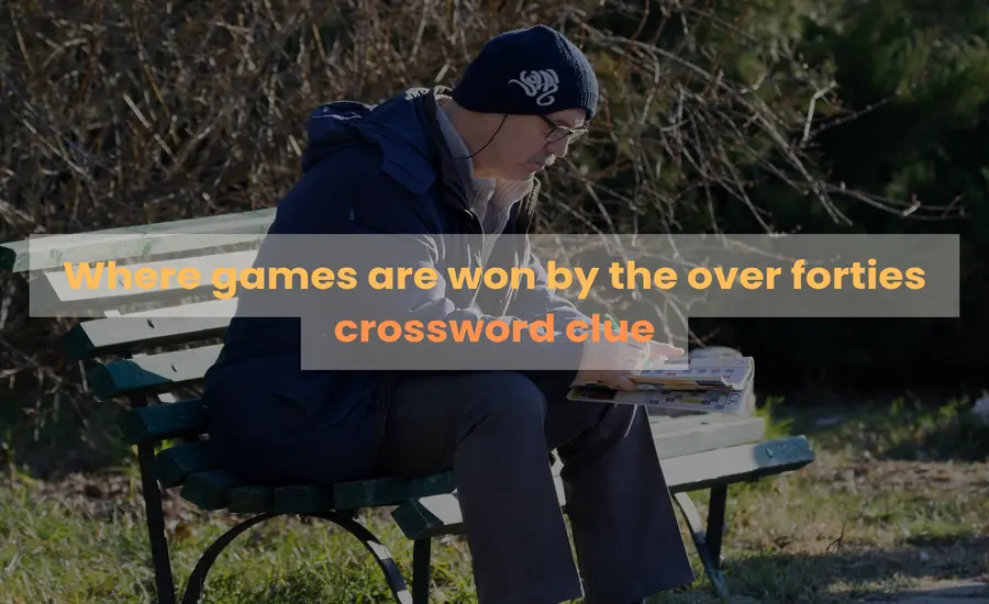 There is a man sitting on the table to read the book in the park.